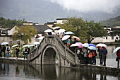China,  Anhui Province,  Hongcun village,  bridge,  people with umbrellas