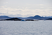 Eisberge und Berge unter Wolkenhimmel, Qaqortoq, Kitaa, Grönland