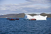People in rubber dinghies driving to iceberg, Kitaa, Greenland