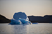Iceberg and coastline at dusk, Narssaq, Kitaa, Greenland