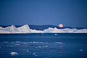 Blick auf Vollmond, Eisberge vom Ilulissat Kangerlua Isfjord und Gebirge in der Abenddämmerung, Ilulissat (Jakobshavn), Diskobucht, Kitaa, Grönland
