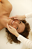 Young woman receiving an ayurveda facial massage, Wellness