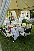 Elegant setting with wrought iron garden furniture under garden pavillon, Munich, Bavaria, Germany