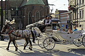 Droschke mit Touristen vor Straßenbahn, ul. Gradzka Ecke Dominikanska, Krakau, Polen, Europa