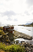 Red rorbu hut on the waterfront at stony coast area, Lofoten, Norway, Scandinavia, Europe