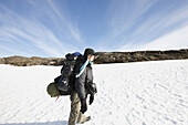 Hiker with rucksack crossing a snow field, Saltfjell, Norway, Scandinavia, Europe