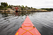 Red kayak in front of the rocky coastline, Skaggerak, Sorland,  Norway, Scandinavia, Europe