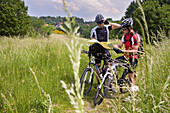 Two mountain bikers reading map, Trippstadt, Palatine Forest, Rhineland-Palentine, Germany