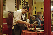 Waiter preparing prosciutto in a restaurant, Cava Baja, Madrid, Spain