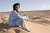 Berber boy in the sand dunes, dunes de Juifs, desert near Zagora, Sahara, Morocco