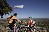 Mountainbiker an einem Strassenschild in Panicale, Umbrien, Italien, Europa