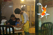 View through aquarium at young chinese family, Kunming, Yunnan, People's Republic of China, Asia