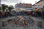 Children throwing chestnuts into the Lollsfeuer Fire at Lullusfest Celebration, Bad Hersfeld, Hesse, Germany