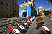 Fahrräder an einem Fahrradverleih im Sonnenlicht, Barcelona, Spanien, Europa