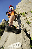 Woman climbing a rock face, name of the route Conte Max written on the rock, natural park Porto Venere, national park Cinque Terre, UNESCO world heritage site, Liguria, Italy
