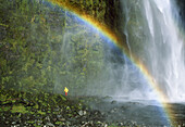 Trekker heading behind Sutherland Falls Milford Track Fiordland National Park New Zealand