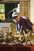 Alter Mann an einem Stand mit Knoblauch, Provencalischer Markt in Buis, Buis-les-Baronnies, Haute Provence, Frankreich, Europa