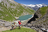 Two women hiking near mountain lake Lac de la Vogealle, Dents Blanches, Haut Giffre, Rhone-Alpes, France