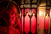 Woman poses in front of a Moroccan lamps at Café Arabe restaurant, Marrakech, Morocco