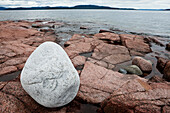 Weisser Felsbrocken auf rotem Granit Fels an der Höga Kusten, Bucht von Storsands Havsbad, Västernorrland, Schweden, Europa