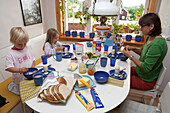 Eine Frau und zwei Mädchen beim Frühstück, Fällsvik, Schweden, Europa