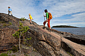 Eine Frau und zwei Mädchen wandern im Naturschutzgebiet Rotsidan, Höga Kusten, Västernorrland, Schweden., Europa