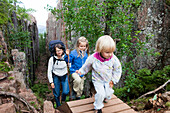 A woman and two girls hiking in the gorge Slattdalsskrevan at national park Skuleskogen, Höga Kusten, Vaesternorrland, Sweden, Europe