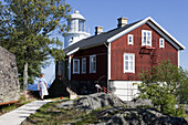Holzhaus und Leuchtturm Högbonden unter blauem Himmel, Höga Kusten, Västernorrland, Schweden, Europa