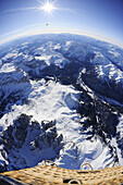 Korb eines Heißluftballon fliegt über Dolomiten mit Langkofel und Grödnerjoch im Vordergrund, Sella und Marmolada im Hintergrund, Luftaufnahme, Dolomiten, Südtirol, Italien, Europa