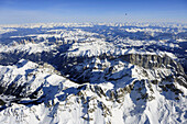 Heißluftballon fliegt hoch über den Dolomiten mit Langkofel, Sella und Südwand der Marmolada im Winter, Dolomiten, Zillertaler Alpen und Tauern im Hintergrund, Luftaufnahme, Dolomiten, Venetien, Italien, Europa