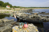 Cliffs and stones and a rowing boat in the sea, Österlen, Skåne, Sweden