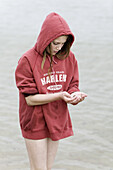 Girl is looking for stones in the water´s edge