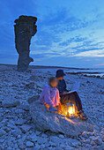 Mother and daughter on beach with sea stacks