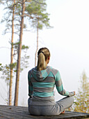 Woman meditates on terrace, Skane, Sweden