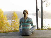 Woman meditates on terrace, Skåne, Sweden