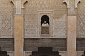 Man looking out of window of Medersa Ben Youssef, adorned walls in muslim style, Marrakech, Morocco, Africa