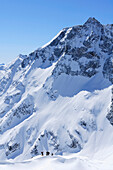 Backcountry skiers beneath Hoher Sonnblick with Zittelhaus hut at the summit, Rauriser Tal valley, Goldberggruppe mountain range, Hohe Tauern mountain range, Salzburg, Austria