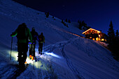 Three men backcountry skiing at night reaching hut Staufner Haus, Hochgrat, Nagelfluh range, Allgaeuer Alpen range, Allgaeu, Bavaria, Germany