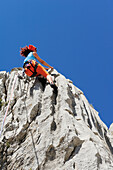 Frau klettert an Felswand, nahe Rifugio Rossi, Pania della Croce, Toskana, Italien