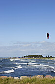 Kitesurfer mit Strandhäuschen im Hintergrund, Skanör, Schonen, Südschweden, Schweden