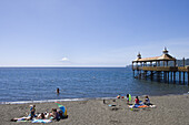 People on beach and pier at Lago Llanquihue lake with view of Osorno Volcano, Frutillar, Los Lagos, Patagonia, Chile, South America, America