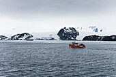 Expedition boat and glacier under clouded sky, False Bay, Livingstone Island, South Shetland Islands, Antarctica