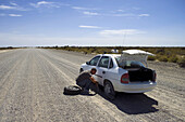 Taxi mit Reifenpanne auf staubiger Piste in der argentinischen Pampa, Peninsula Valdes Nationalpark, Valdes Halbinsel, Patagonien, Argentinien, Südamerika, Amerika