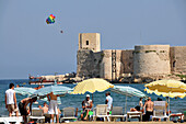 Men on the beach, view of the girlcastle, Kiz Kalesi, Kalikien, south coast, Anatolia, Turkey