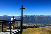 Man looking from chapel Santa Maria degli Angeli, (Architect: Mario Botta), Alpe Foppa, hike in the mountains to Monte Tamaro, Ticino, Switzerland