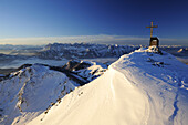 Cross and chapel at the summit of Geigelstein, Kaisergebirge mountain range in the background, Geigelstein, Chiemgau mountain range, Bavarian Alps mountain range, Upper Bavaria, Bavaria, Germany