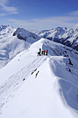 Group of people backcountry skiing, standing on a ridge, Hinterbergkofl, Staller Sattel, Villgratner Berge range, South Tyrol, Italy