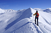 Frau auf Skitour steigt auf Schneegrat auf, Kreuzjöchl, Tuxer Alpen, Tirol, Österreich