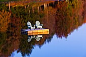 two adirondack chairs on dock in autumn