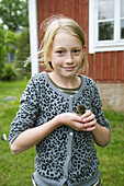 Young girl with baby duck on her hand.